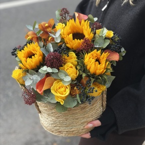 Композиция в сумке "Тональность" из подсолнухов, калл, ягод вибирнума, лимонных роз, скиммии и орхидеи в Воскресенске